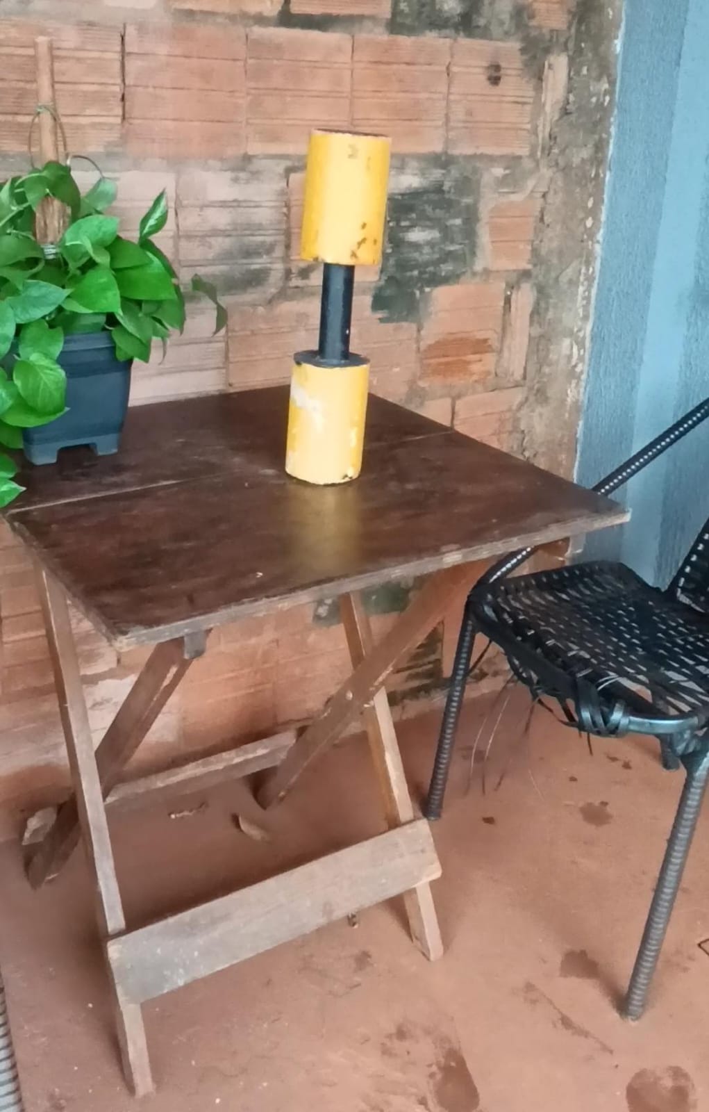 Onde tudo começou — mesa de madeira dobrável, peso de academia usado como suporte pra filmar com o celular